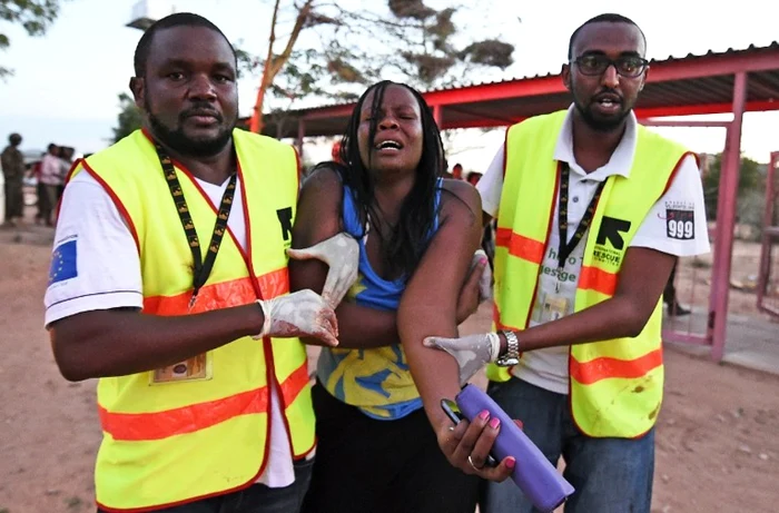 Paramedicii ajută o tânără rănită în timpul atacului de joi, de la Universitatea Garissa din Kenya