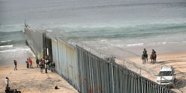 Oameni privesc grănicerii americani cum patrulează lângă zidul care separă Statele Unite de Mexic la ocenul Pacific în Tijuana Mexic FOTO Guliver / Getty Images / Scott Olson