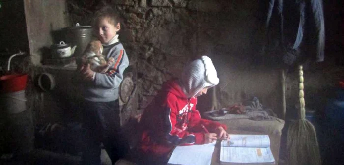 În bordei se înghesuie cei patru membri ai familiei, un motan şi un câine