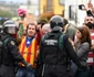 Un bărbat îmbrăcat în steagul Cataloniei cu un buchet de flori în mână salută în timp ce poliţia încearcă să prevină iscarea unui conflict. FOTO Guliver/gettyimages