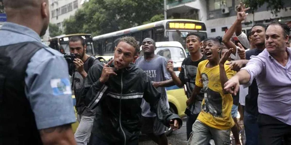 Locuitori din mahalaua Pavao-Pavaozinho strigă la un poliţist în timpul unui protest faţă de moartea lui Douglas Rafael da Silva Pereira de 25 de ani în Rio de Janeiro Brazilia FOTO Reuters