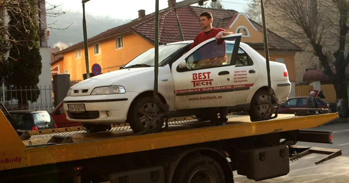 Silvestru Pop este doar unul dintre braşovenii care a protestat direct pe platforma cu care i-a fost ridicată maşina. Foto: Stelian Grăjdan