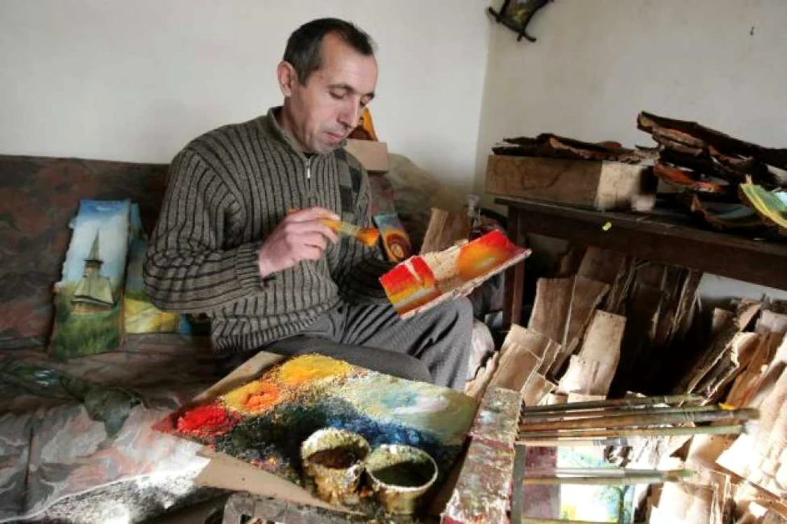 Florin Vîlcu pictează pe scoarţă de copac. Foto: Victor C. Boldîr.