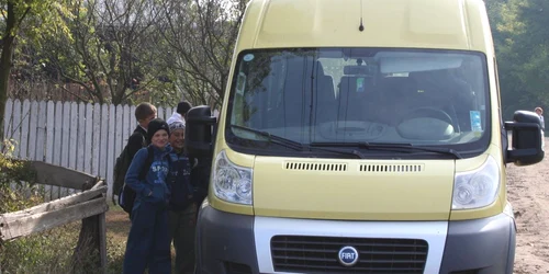 Elevii aşteaptă să urce în microbuzul care îi duce spre şcoala din comună