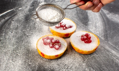 top view delicious cranberry cakes baked yummy getting sugar powder with red cranberries top grey desk cake biscuit sugar sweet jpg