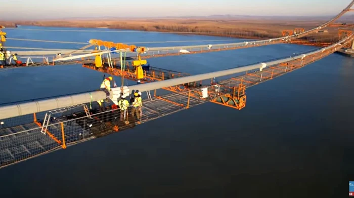 Muncitorii japonezi montează cablurile podului: Foto: captură youtube Raducu P Drum