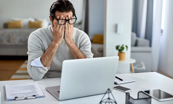 businessman feeling exhausted after working laptop home jpg