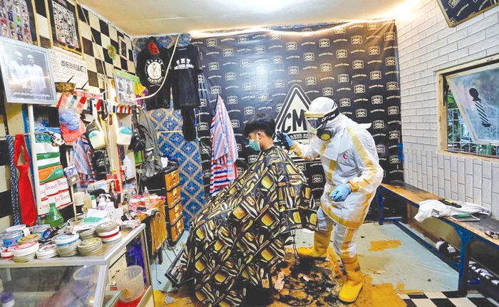 Herman Maulanasyah îşi tunde clientul costumat regulamentar pentru COVID-19