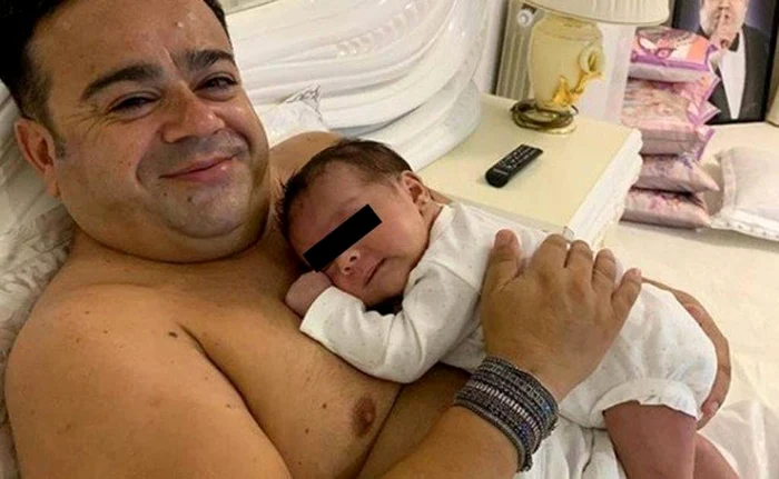 Adi Minune o adoarme pe nepoţica Sofia la piept, în dreptul inimii