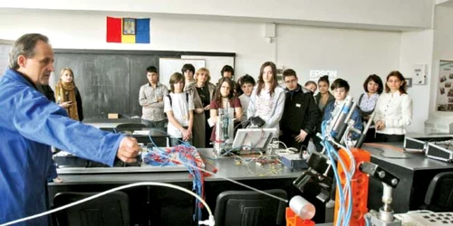 Elevii asistă la o demonstraţie în atelierul de mecatronică