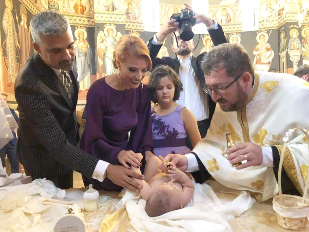 Momentul în care preotul o miruie pe micuța Clara Maria