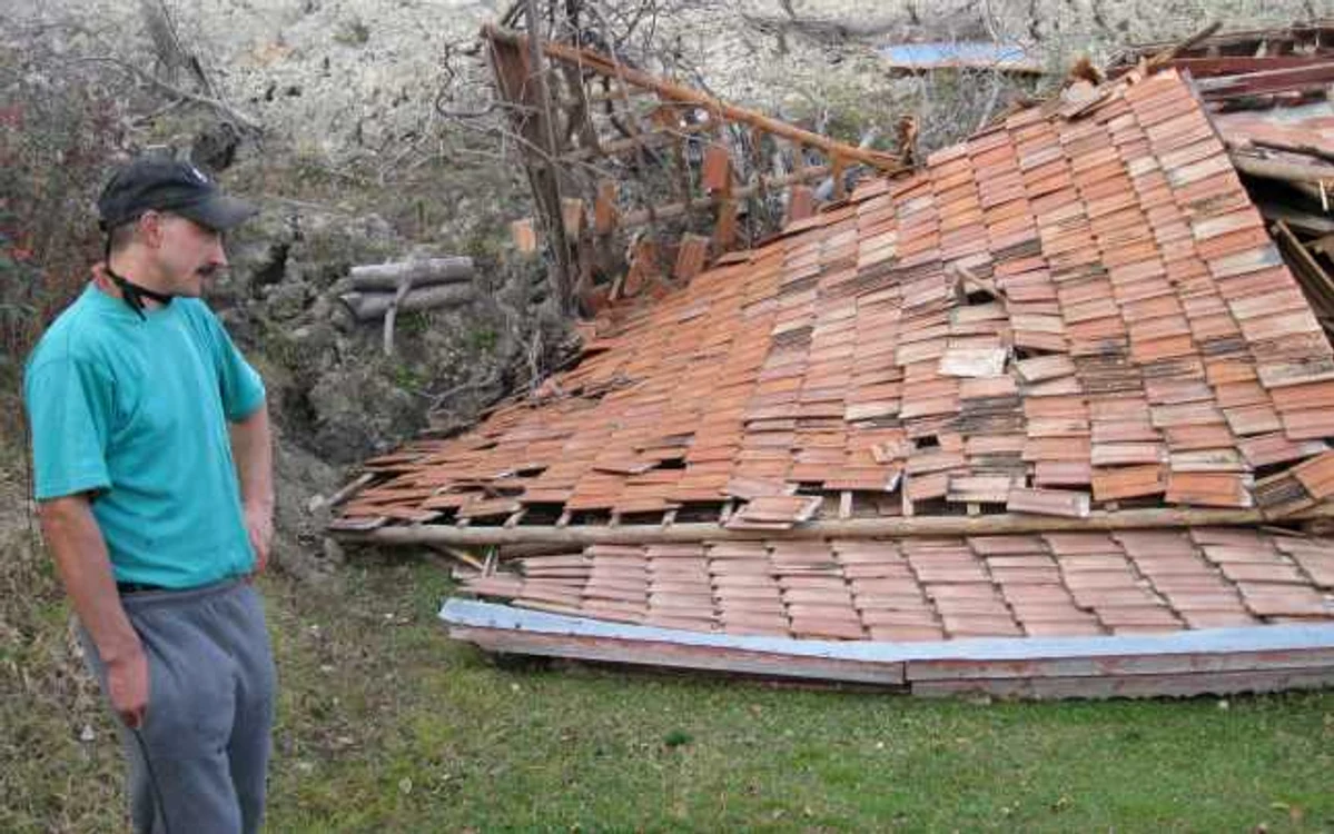 Ion Dinu se uită la casa dărâmată