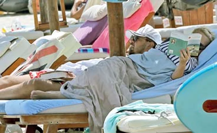 
    Învelit cu un prosop şi cu şapca  trasă pe ochi, Brenciu a adormit  buştean fiind la un pas să  scape cartea din mânăFoto: Mihai Ionescu  