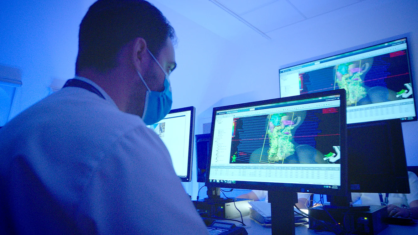 Medic vizualizând ședința de radioterapia pe pc