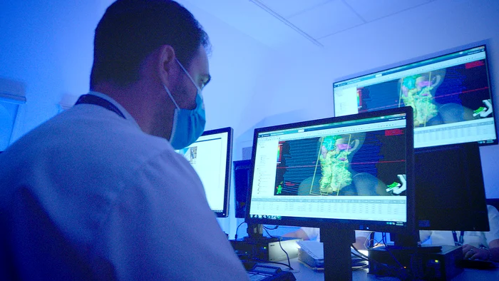 Medic vizualizând ședința de radioterapia pe pc