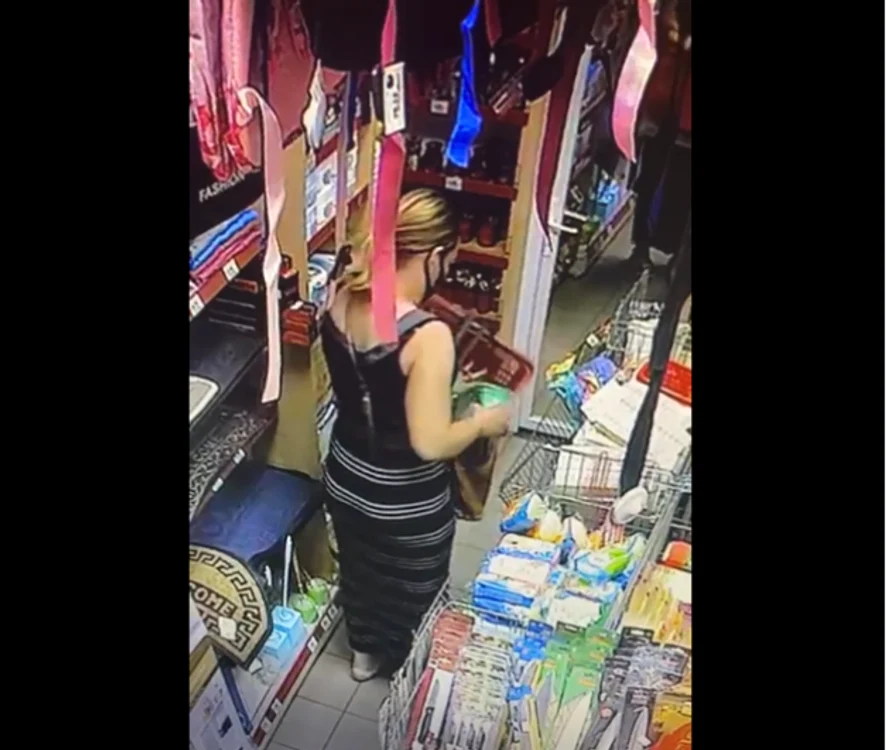Femeia strecoară în geantă conţinutul unei cutii cu detergent, fără să plătească la casă produsul