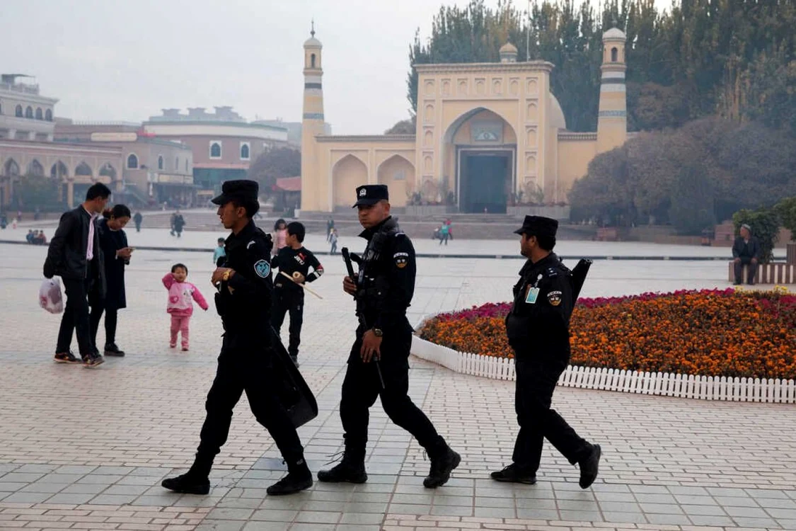 Foto: Personalul de securitate uigur patrulează lângă Moscheea Id Kah din Kashgar, un oraş din regiunea Xinjiang din nord-vestul Chinei, în 2017. Autorităţile de la Beijing pretend că nu există problema „drepturilor omului” în această provincie. Sursa: Ng Han Guan/AP.