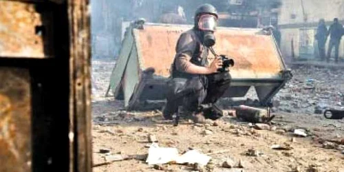 Fotoreporterul francez Rémi Ochlik se fereşte de gaze lacrimogene, la Cairo p Fotografii: reuters