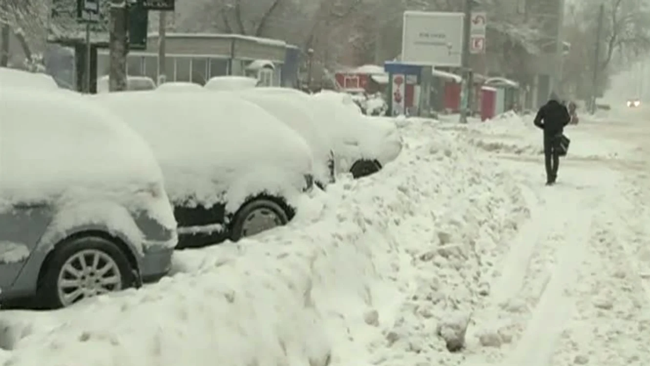 
    Pentru că trotuarele nu sunt curățate de zăpadă, pietonii sunt nevoiți să își facă loc chiar pe stradă, printre mașini  