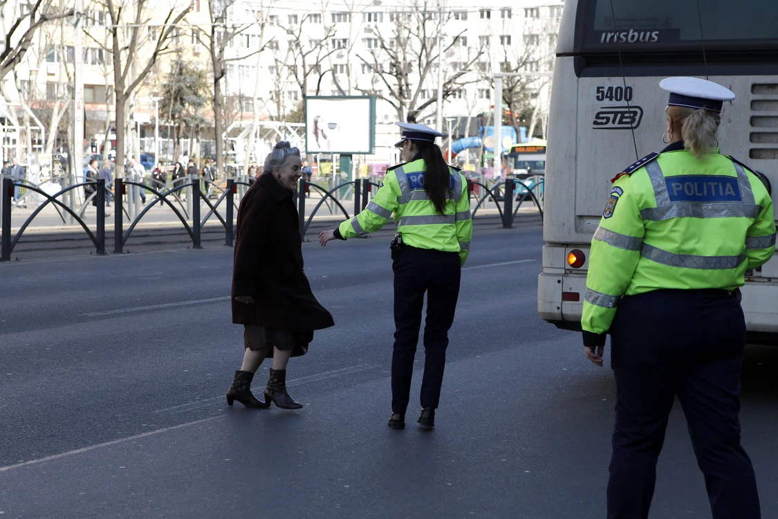 
    Polițista s-a dus repede să o ia de mână pe femeia care alerga prin fața mașinilorFotografii: Eduard Enea  