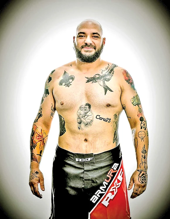 Este plin de mușchi și de tatuaje