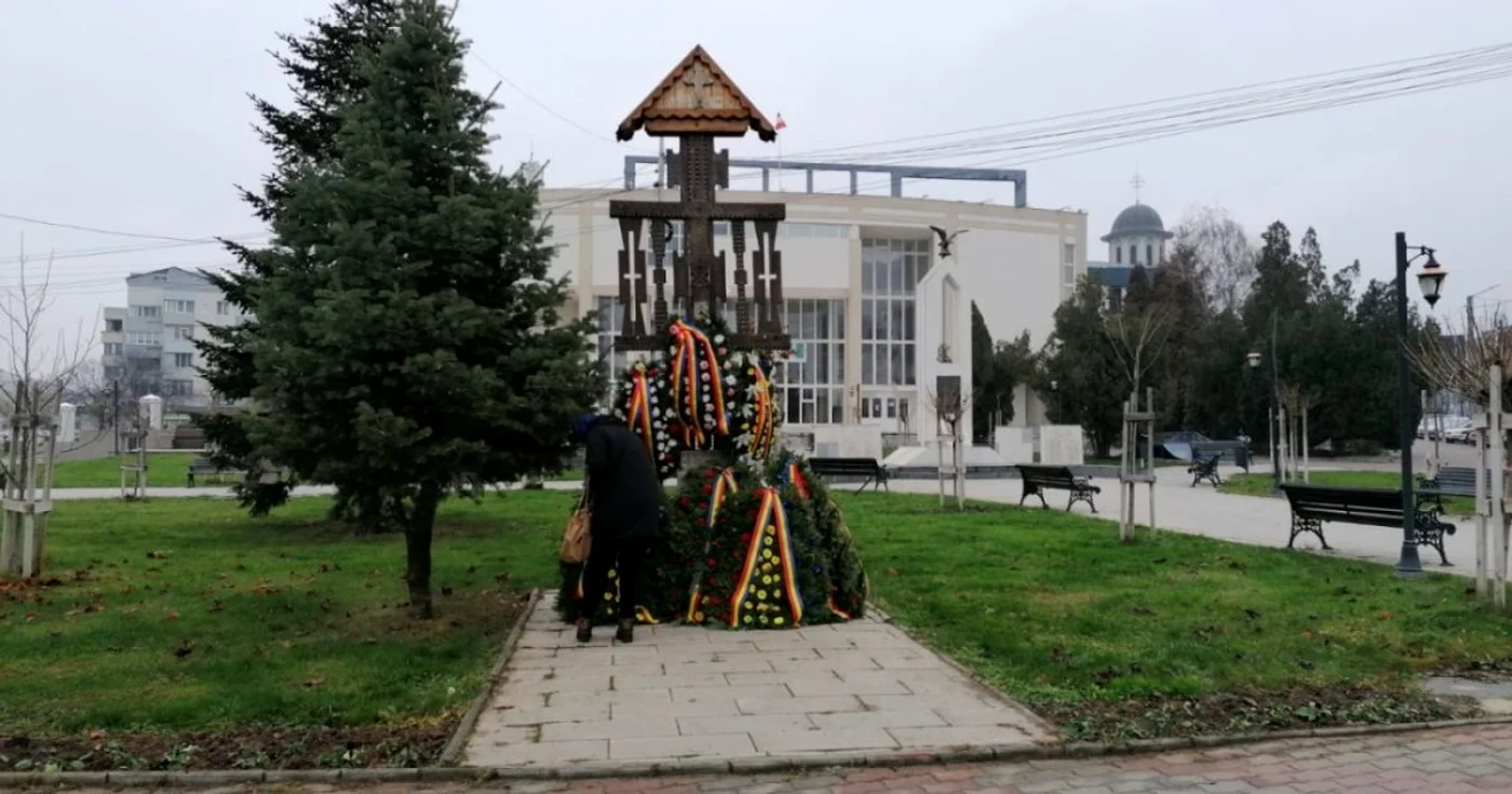 Pensionara s-a oprit în faţa troiţei, cercetând numele celor care au căzut sub gloanţe FOTO: Alina Mitran