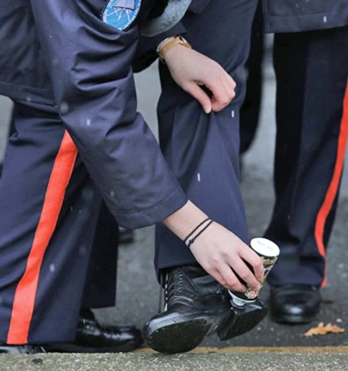 Un elev al Colegiului Național ”Ștefan cel Mare” îi lustruiește bocancii camaradului