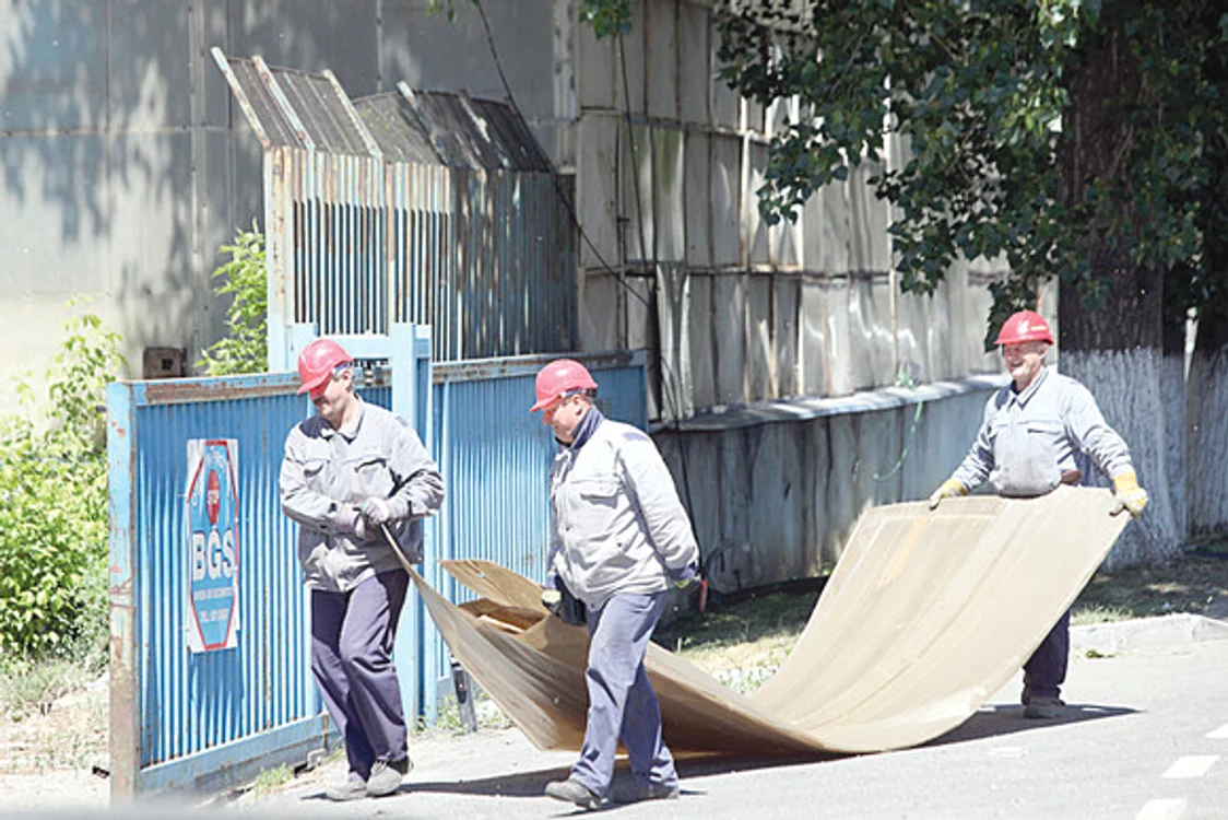 
    Câțiva muncitori își fac de lucru printre ruinele fostului colos industrial  