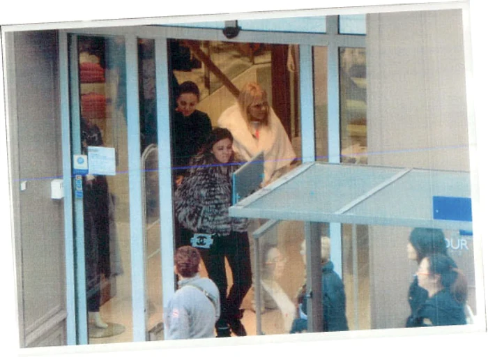 Fetele ies din magazine de firmă încărcate de cumpărături