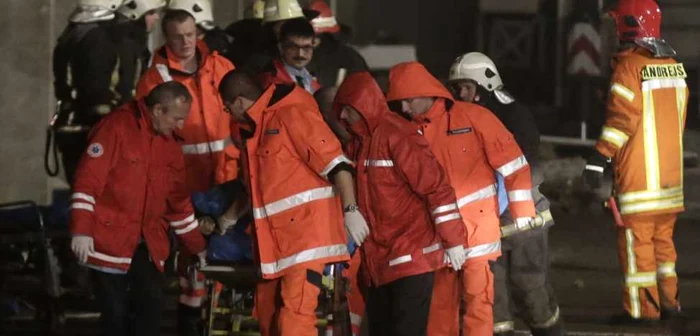 Paramedicii transportă cadavrele de la locul dezastrului. FOTO: Reuters
