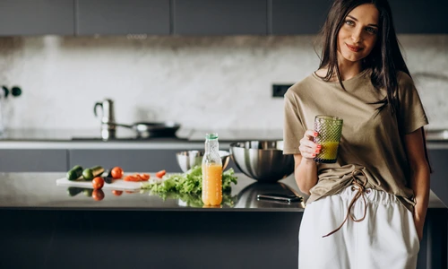 young woman drinking juice home jpg