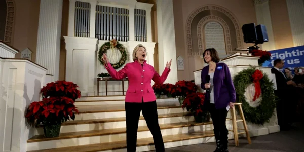 Candidatul democrat la alegerile prezidenţiale Hillary Clinton reacţionează la aplauzele publicului alături de Brenda Bouchard o susţinătoare a persoanelor cu Alzheimer în timpul unui eveniment de campanile la South Church în Portsmouth New Hampshire