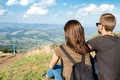 young couple enjoying mountains landscape sitting hill jpg