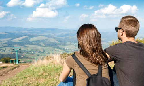young couple enjoying mountains landscape sitting hill jpg