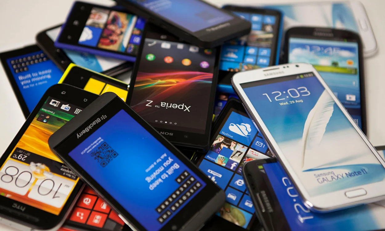 Multe telefoane așezate unele peste altele pe o masă