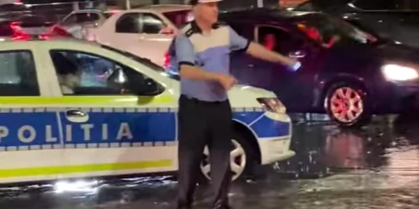 seful politiei rutiere din Bucuresti, dirijeaza traficul in mijlocul ploii torentiale jpeg