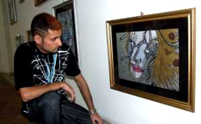 Pictorul Dănăilă Alexandru, "Aldyn", în faţa uneia dintre lucrările sale din expoziţia Interferenţe