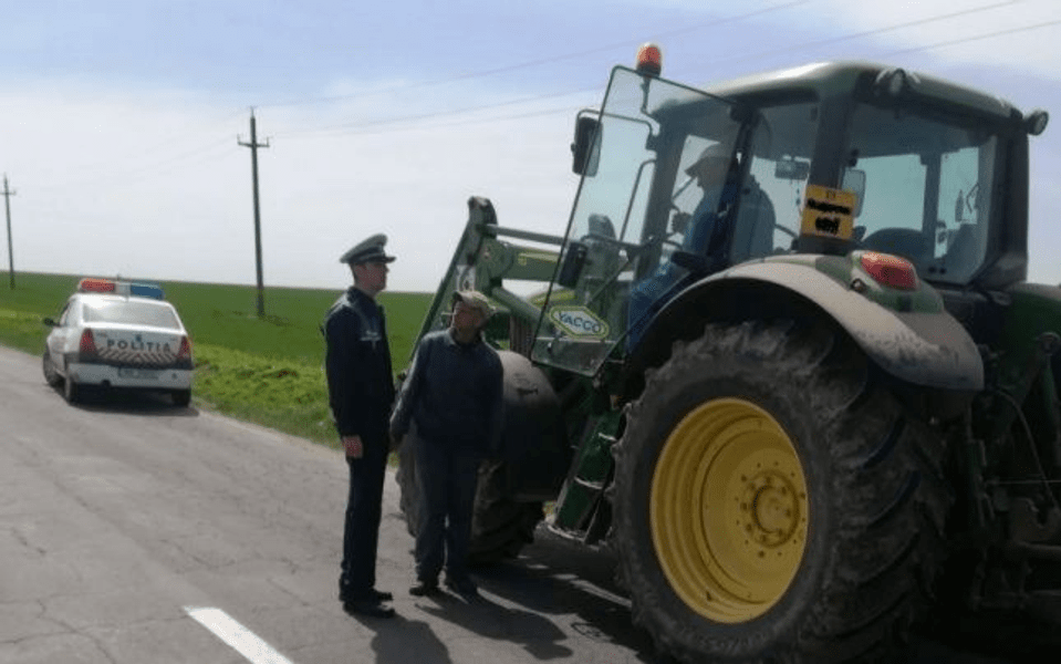Tractorist rupt de beat, oprit pe șosea de polițiști. Circula fără lumini și fără numere