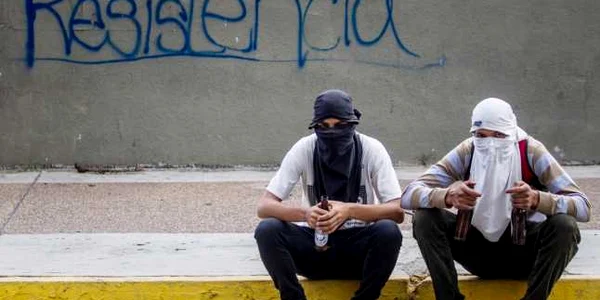 Două persoane stau în timpul unui marş al opoziţiei la Caracas Venezuela FOTO EPA / Miguel Gutierrez