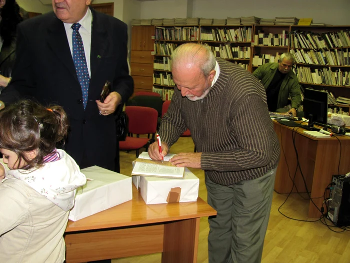 Profesorul Nicolae Hilohi semnează faximilul Abecedarului 