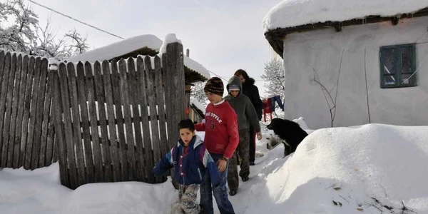 Copiii din comunităţi sărace înoată prin zăpadă