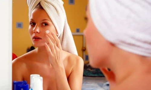 shutterstock 22998823 femeie oglinda crema fata jpeg