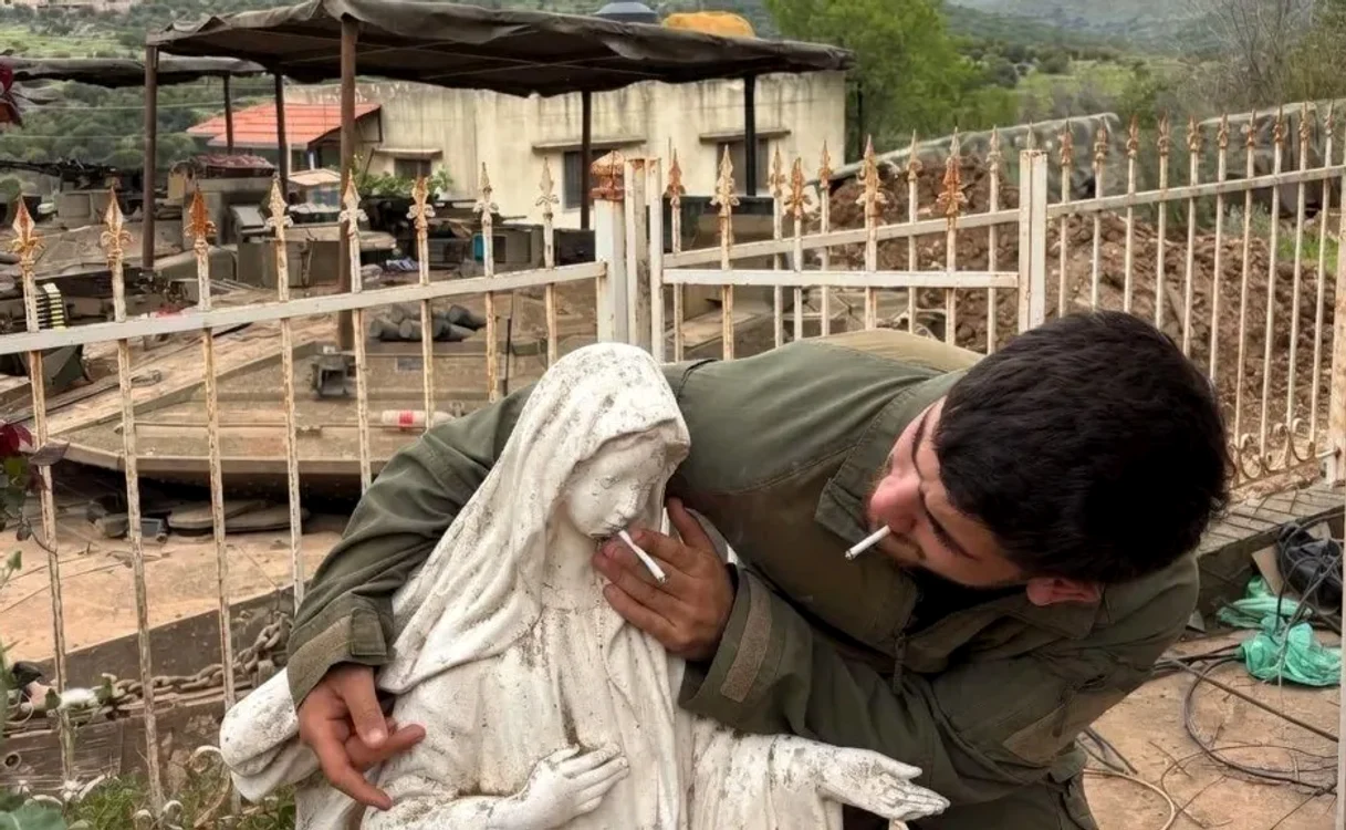 Soldatul israelian apropie o țigară de statuia Fecioarei Maria FOTO: X