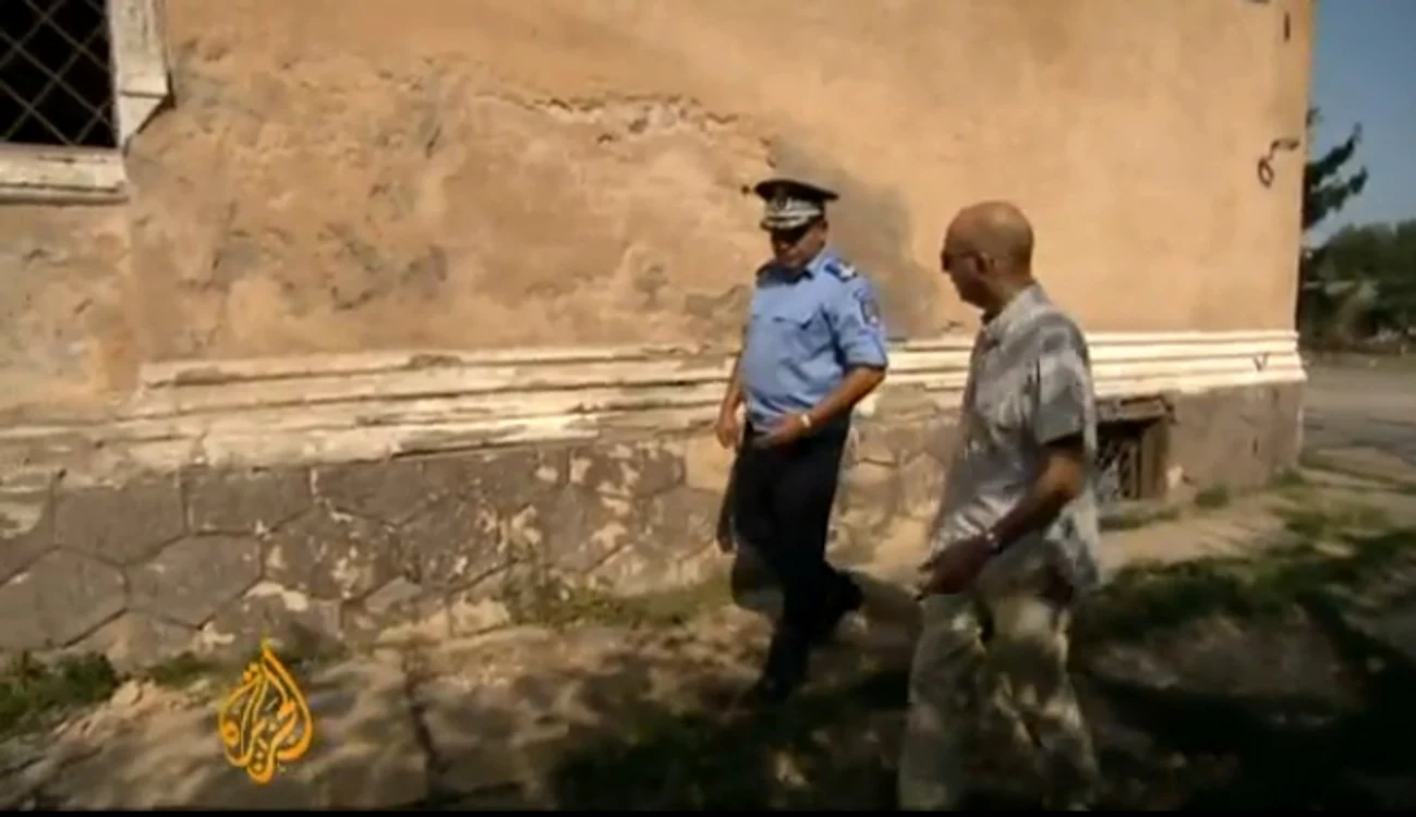 Reporterul Al Jazeera examinează peretele unde au fost împuşcaţi soţii Ceauşescu