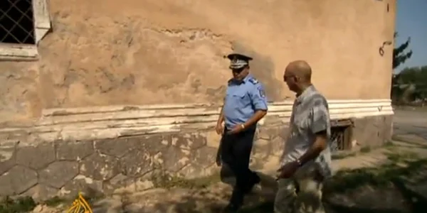 Reporterul Al Jazeera examinează peretele unde au fost împuşcaţi soţii Ceauşescu