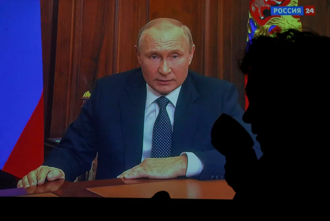 O refugiată din Mariupol își bea cafeaua în timp ce Putin susține un discurs la TV | FOTO EPA EFE