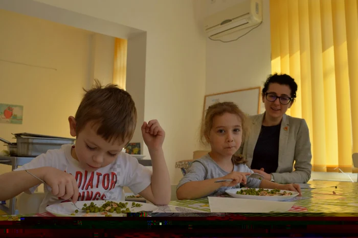 Doi dintre elevii din centrul de la Ploieşti, la masa de prânz. Mănâncă împreună cu Alexandra (în foto), dar şi cu ceilalţi profesori