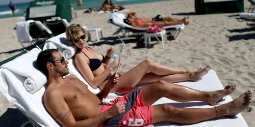 Vinnie Miliano (L) şi Erin McGrath petrec o zi la plajă după ce zborul de întoarcere la New York a fost amânat iar majoritatea aeroporturilor de pe Coasta de Nord-Est au fost închise din cauza furtunii de zăpadă în Miami Beach Florida FOTO Guliver/Ge