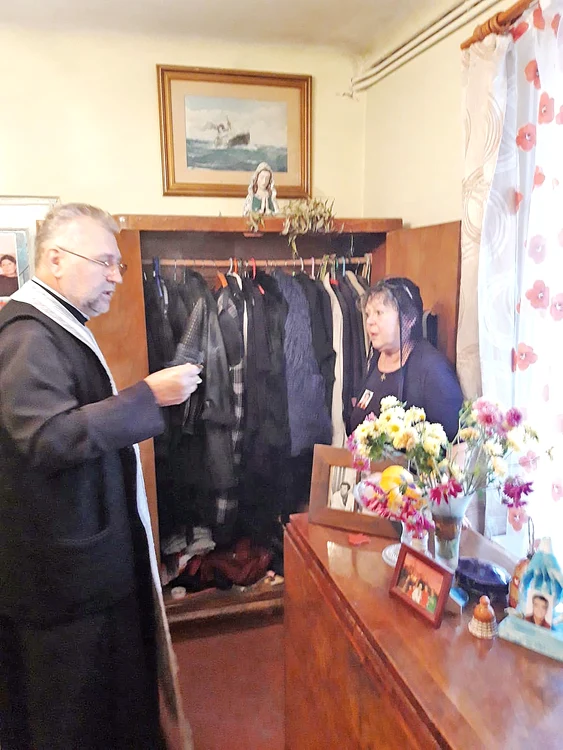 Preotul a sfinţit hainele care vor fi date de pomană