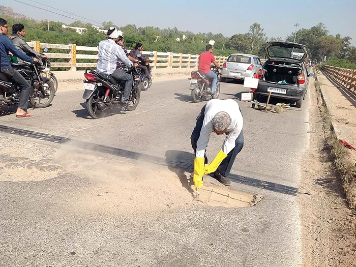 Bărbatul munceşte singur la repararea asfaltului